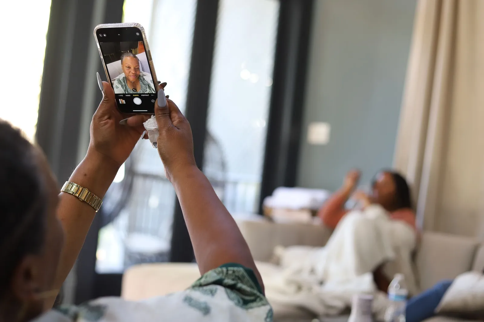 A retreat attendee holding up her phone so a woman joining virtually can take part