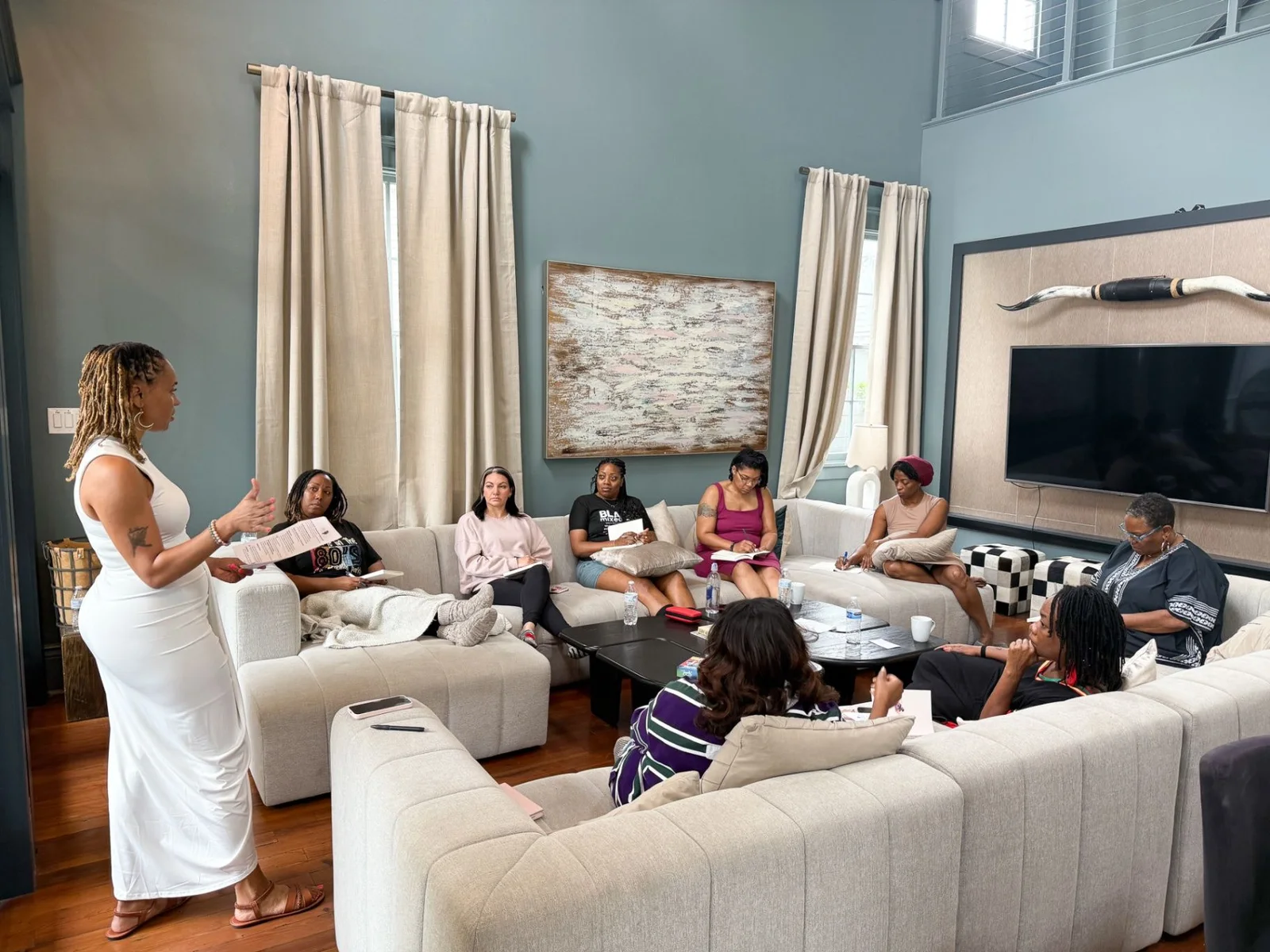 Siobhan Middleton standing and speaking to women seated around a living room at the retreat